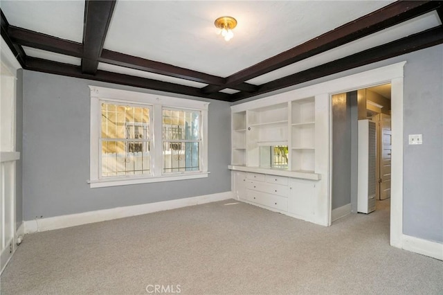 interior space with baseboards, coffered ceiling, beamed ceiling, and light colored carpet