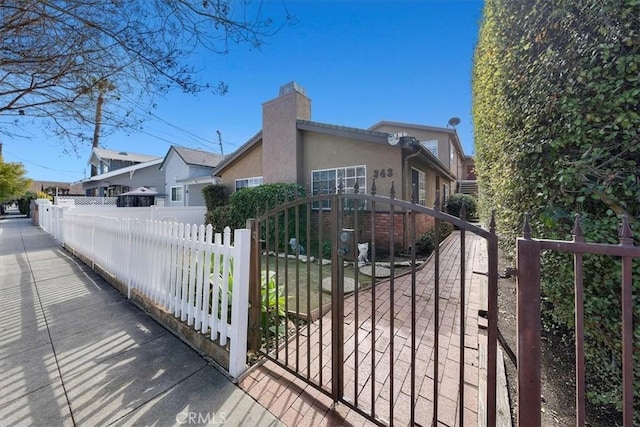 view of gate with a fenced front yard