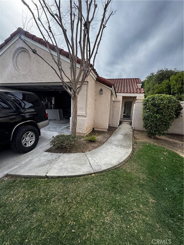 mediterranean / spanish-style house with a garage, a tile roof, and stucco siding