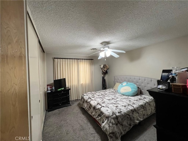 carpeted bedroom featuring a ceiling fan and a textured ceiling