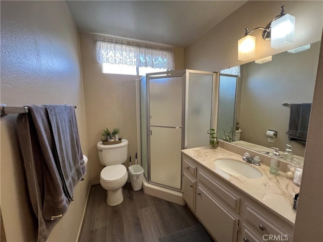 full bath with toilet, a shower stall, wood finished floors, and vanity