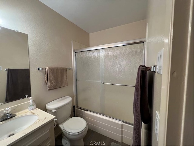 bathroom featuring toilet, vanity, and enclosed tub / shower combo