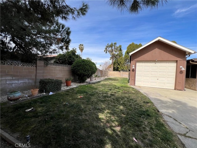 view of yard featuring a garage, a fenced backyard, and driveway