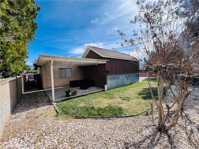 exterior space featuring a patio area, fence, and a lawn