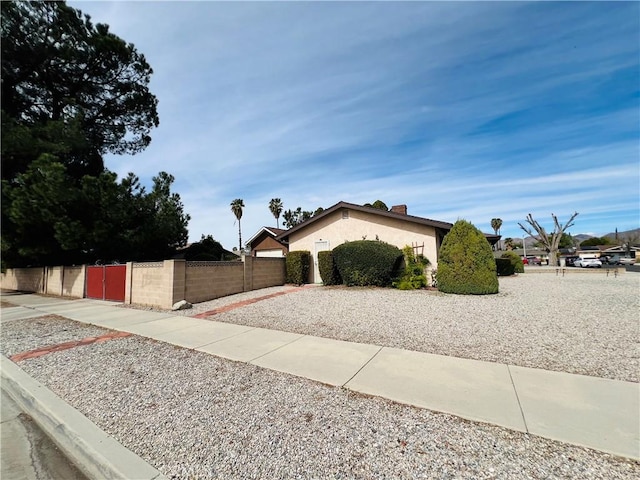 view of home's exterior featuring a fenced front yard, a gate, and stucco siding