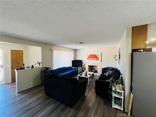 living room featuring a textured ceiling, a fireplace, and dark wood-type flooring