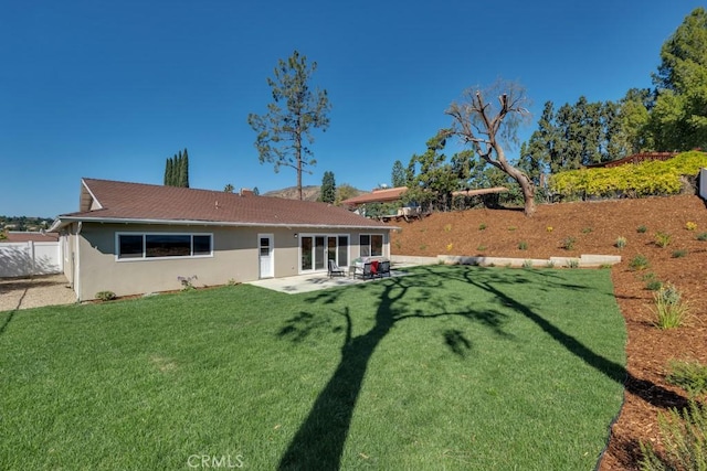 back of house featuring a patio, a yard, a fenced backyard, and stucco siding