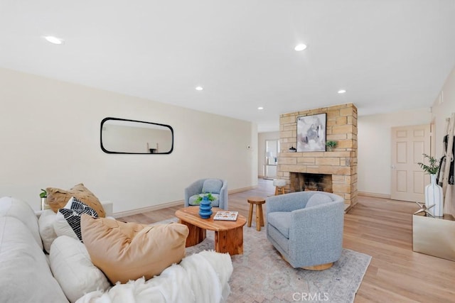 living room featuring light wood-style floors, recessed lighting, a fireplace, and baseboards