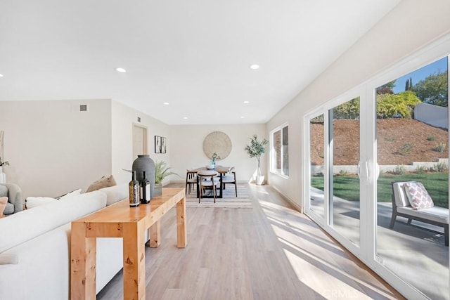 living room featuring light wood finished floors, visible vents, and recessed lighting