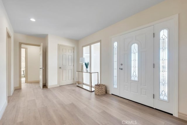 foyer featuring light wood-style flooring, baseboards, and recessed lighting