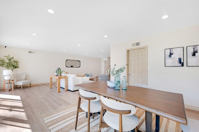 dining area featuring baseboards, light wood finished floors, visible vents, and recessed lighting