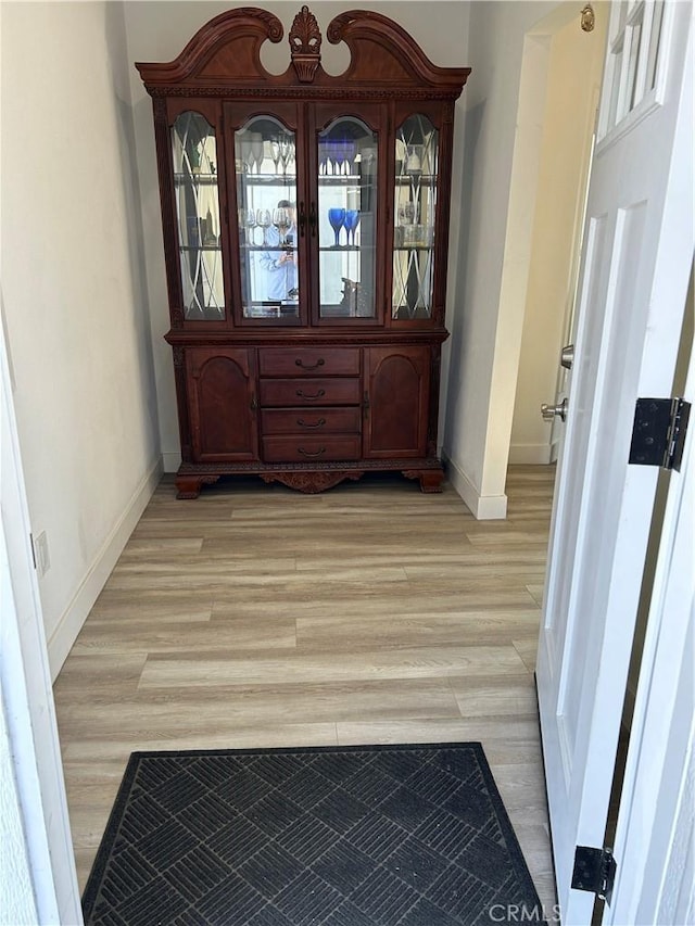 unfurnished dining area with light wood-style floors and baseboards