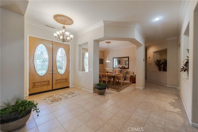 foyer entrance featuring a chandelier, a wealth of natural light, visible vents, and baseboards