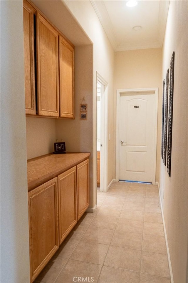 hall with baseboards, light tile patterned flooring, and crown molding