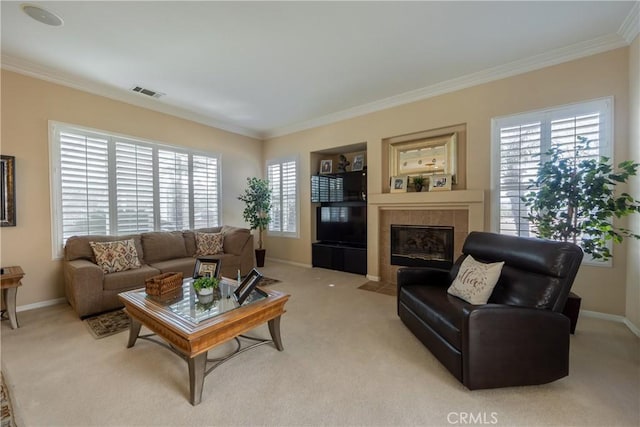 living room with crown molding, visible vents, a tiled fireplace, and light colored carpet