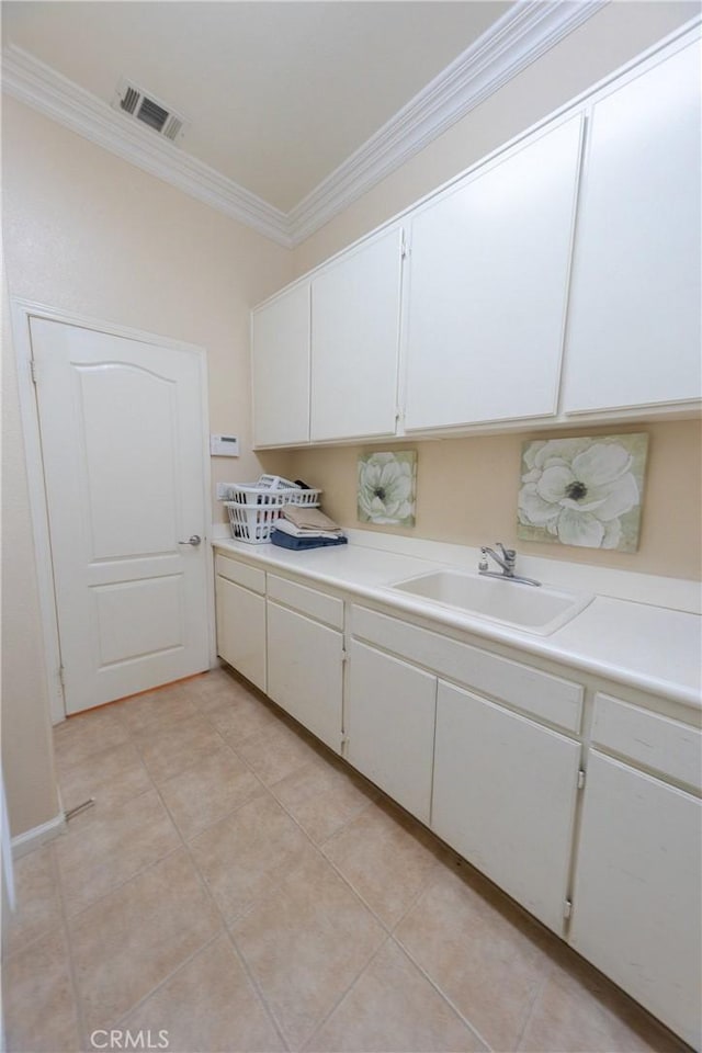 kitchen featuring light countertops, a sink, white cabinets, and crown molding