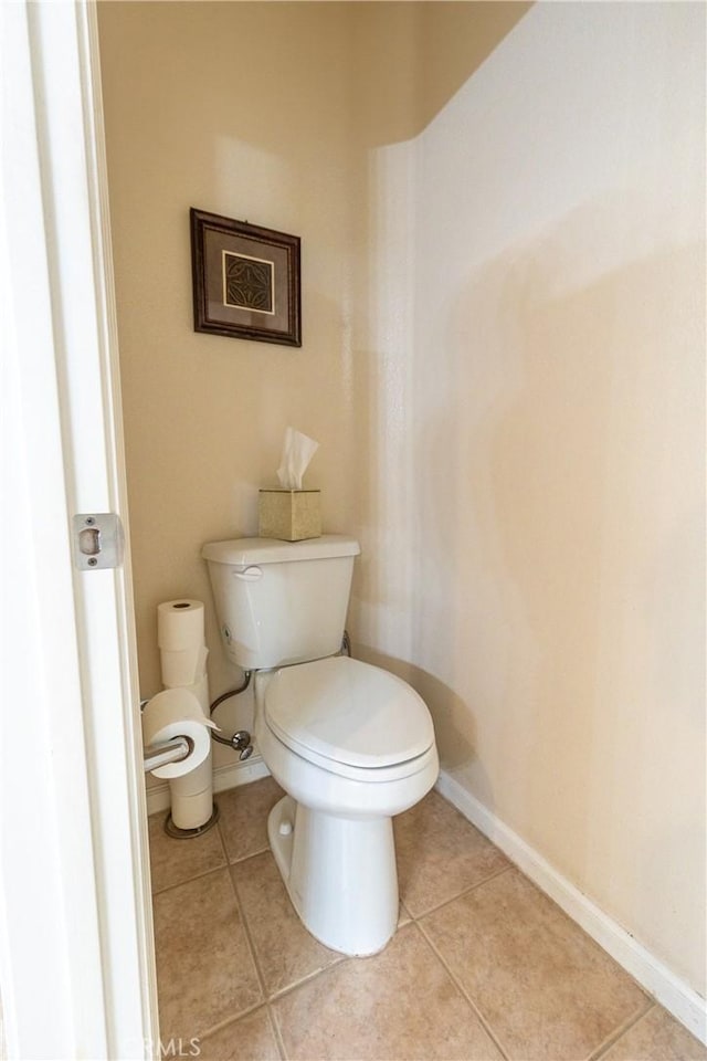 bathroom featuring toilet, baseboards, and tile patterned floors