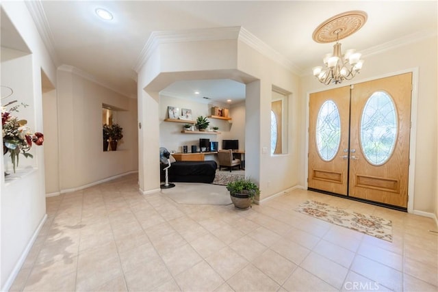 foyer with ornamental molding, baseboards, an inviting chandelier, and light tile patterned floors