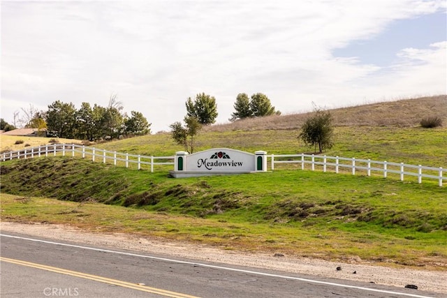 community sign with a rural view and fence