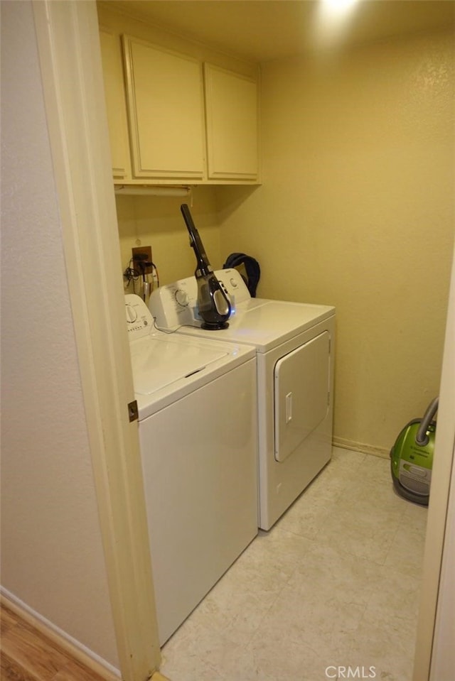 laundry room with baseboards, cabinet space, and washing machine and clothes dryer