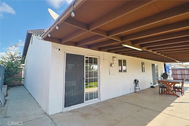 view of patio with outdoor dining area and fence