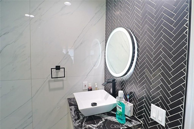 bathroom with a sink and tile walls