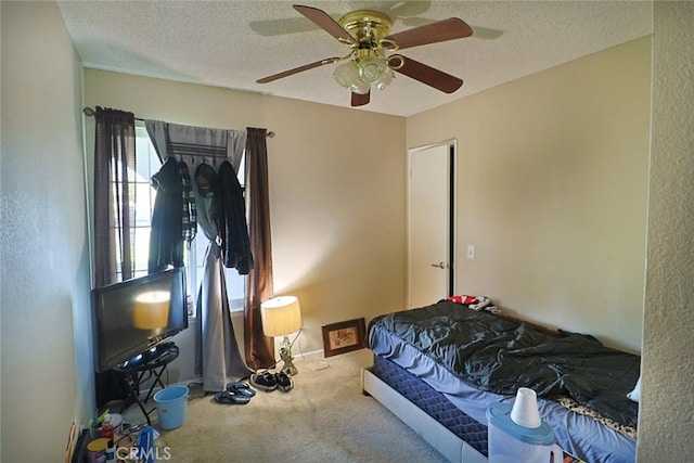 carpeted bedroom featuring a ceiling fan, baseboards, and a textured ceiling