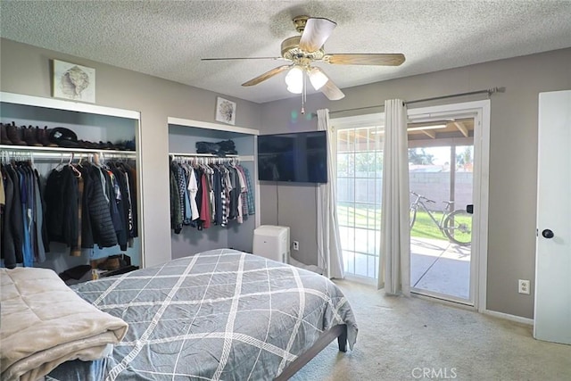 bedroom with a textured ceiling, access to exterior, two closets, and carpet floors