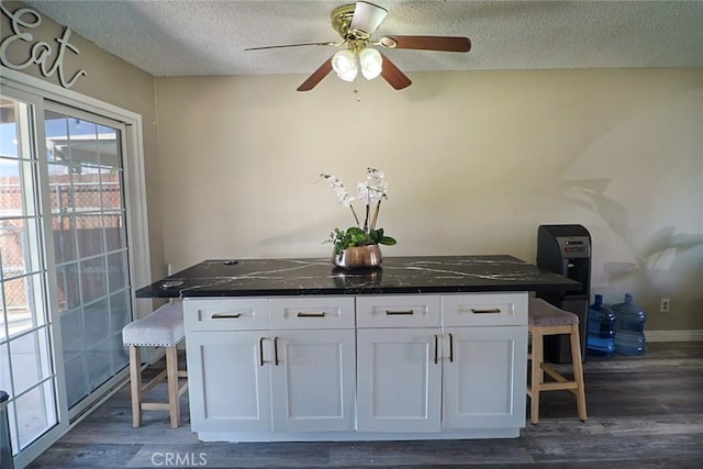 kitchen with white cabinetry, a breakfast bar area, and dark wood-style flooring