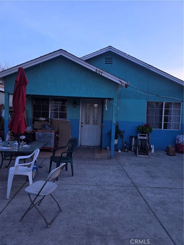 rear view of property featuring a patio area and stucco siding