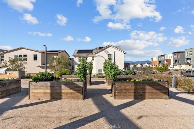 exterior space with a garden, fence, and a residential view