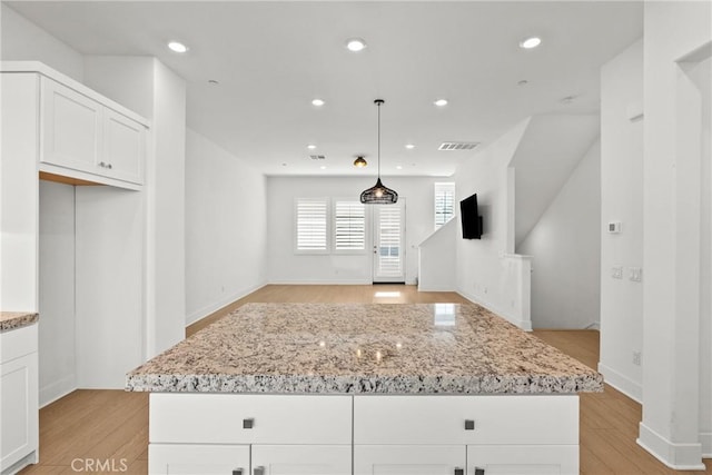 kitchen with white cabinets, visible vents, open floor plan, and pendant lighting