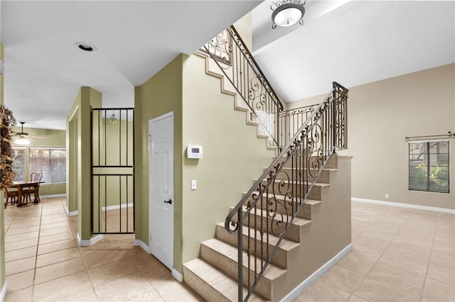 stairs with vaulted ceiling, tile patterned flooring, and baseboards