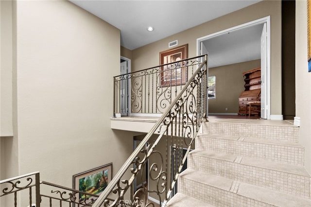 stairway with visible vents, baseboards, and recessed lighting