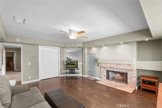 living area featuring visible vents, baseboards, and wood finished floors