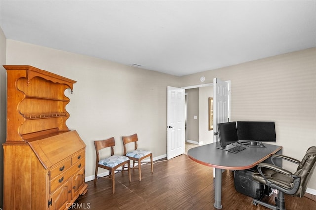 office space with dark wood-style floors, visible vents, and baseboards