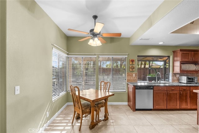 kitchen with a toaster, a sink, baseboards, stainless steel dishwasher, and tasteful backsplash