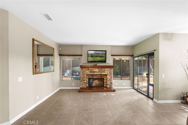 unfurnished living room with tile patterned flooring, visible vents, a fireplace, and baseboards