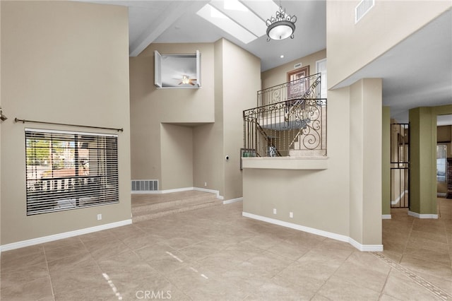 interior space featuring a skylight, visible vents, and baseboards