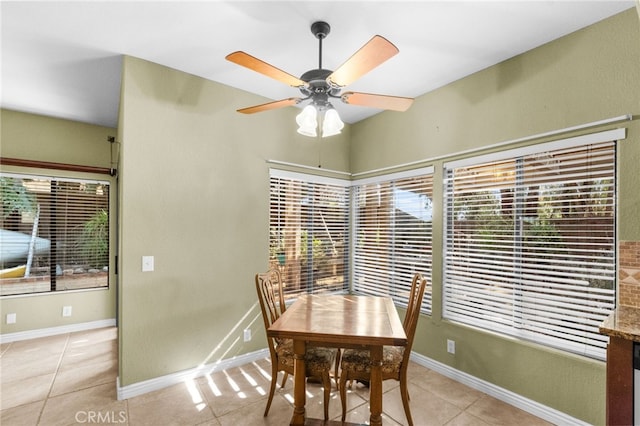 dining area featuring light tile patterned floors, ceiling fan, and baseboards