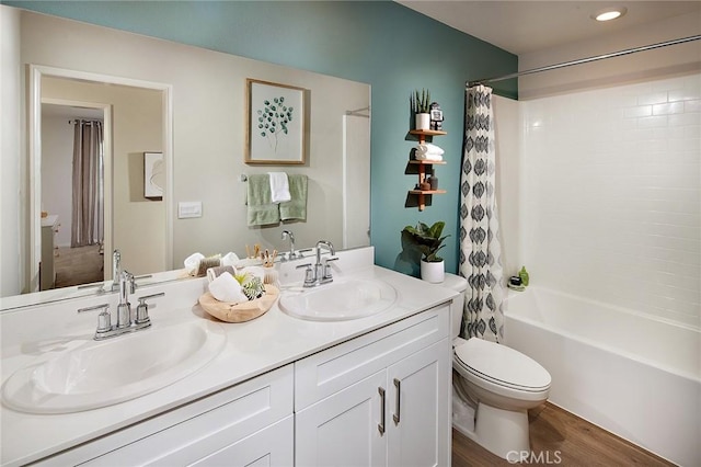 full bath with double vanity, wood finished floors, a sink, and shower / tub combo with curtain