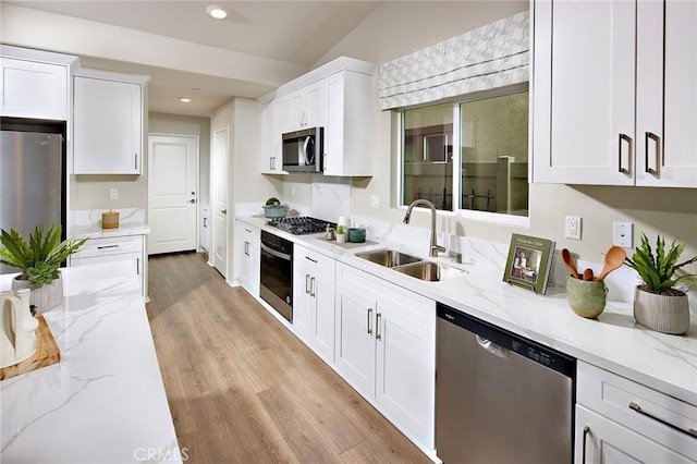 kitchen featuring appliances with stainless steel finishes, a sink, and white cabinetry