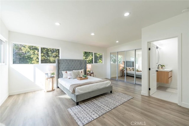 bedroom with baseboards, recessed lighting, and light wood-style floors