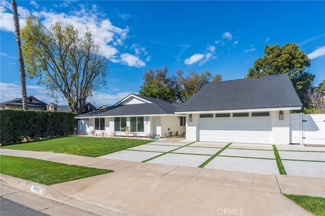 ranch-style home featuring concrete driveway, an attached garage, a gate, a front yard, and brick siding