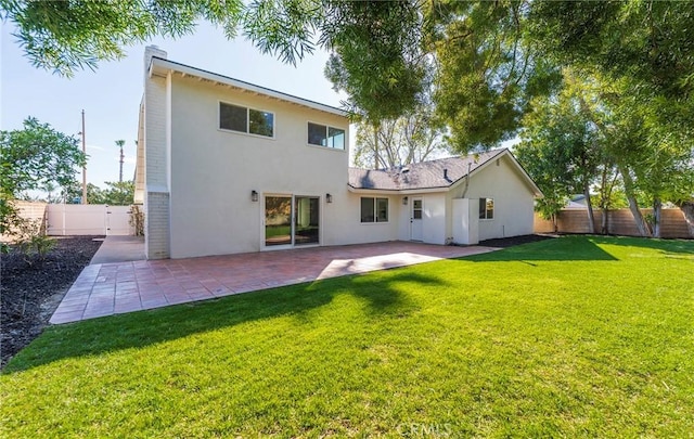 rear view of property featuring a patio area, fence, stucco siding, and a yard