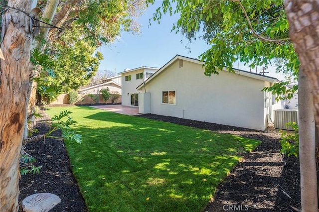 view of yard with central air condition unit, a fenced backyard, and a patio