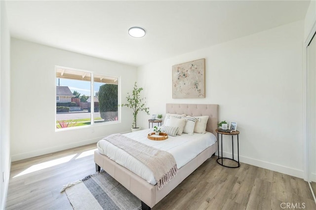 bedroom featuring baseboards and wood finished floors