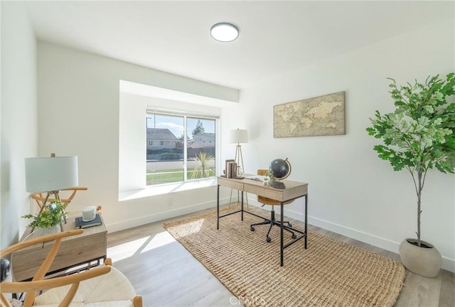 office space with baseboards and wood finished floors