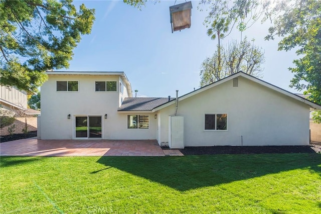 back of house featuring a patio, a lawn, and stucco siding