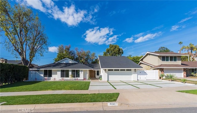 view of front of property with a front yard, a gate, fence, a garage, and driveway